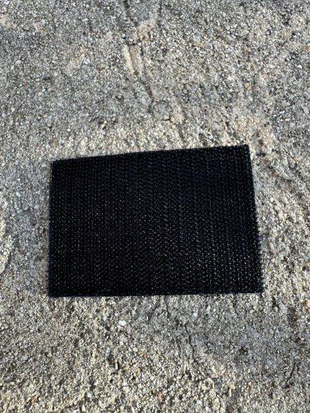 Black textured mat on rough surface.